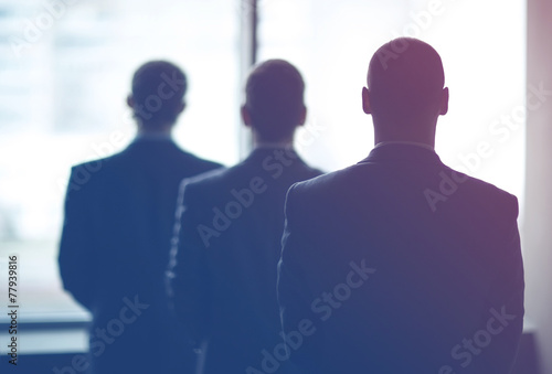 silhouette of three businessmen in the office photo