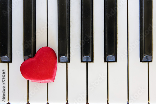 Red heart on piano keyboard