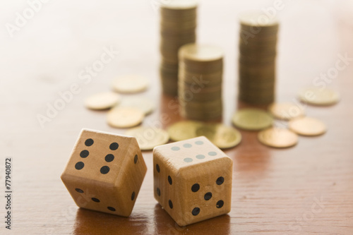 Dice with pile of money on a table