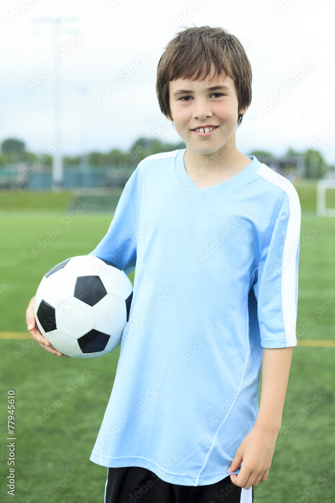 A young soccer player with ball on the field