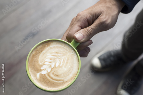Hand holding a cup of coffee