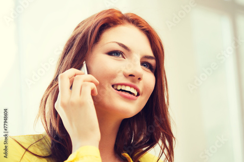 smiling teenage girl with smartphone at home