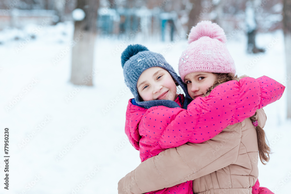 Happy girls playing on snow in winter