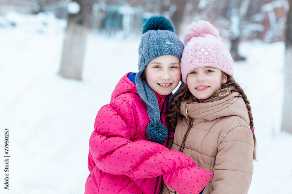 Happy girls playing on snow in winter