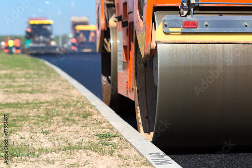 фотографія Road roller compacting asphalt near curb stone