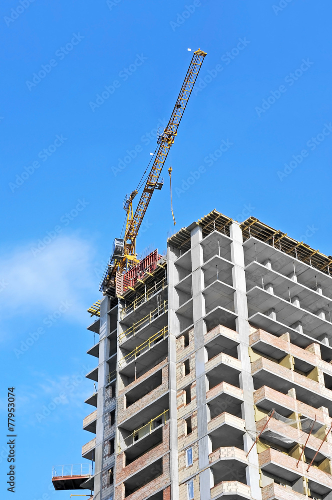 Crane and building construction site against blue sky Crane and building construction site against blue sky