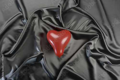 Tela gris y globo rojo en forma de corazón