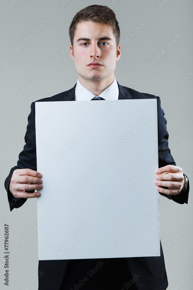 Businessman holding empty white placard showing copy space. Businessman holding empty white placard showing copy space.