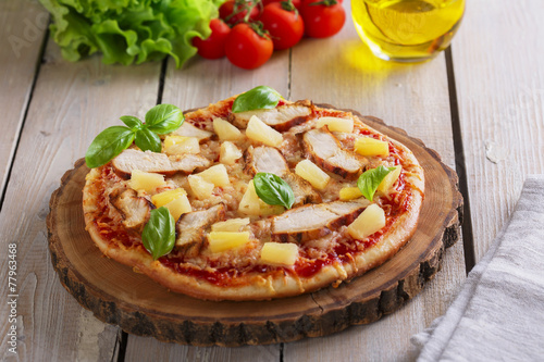 Pizza with cheese and pineapple chicken on board