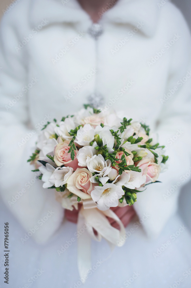 Winter wedding bouquet in hands of the bride closeup Winter wedding bouquet in hands of the bride closeup