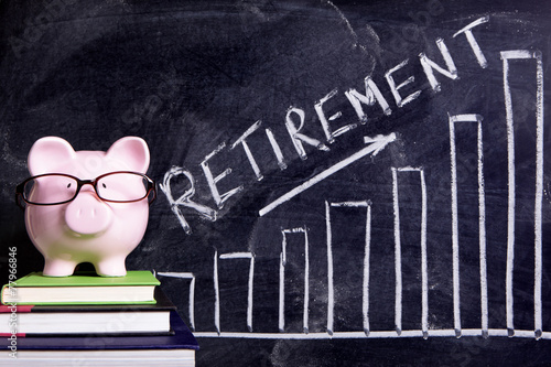 Piggy Bank piggybank wearing glasses with retirement savings plan message and chart written on a blackboard or chalk board photo