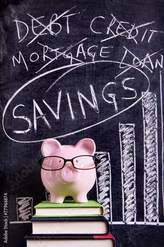 Piggy Bank piggybank wearing glasses with savings plan message and chart written on a blackboard or chalk board photo