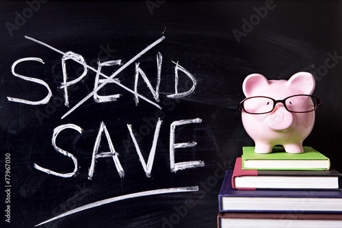 Piggy Bank piggybank wearing glasses with savings plan message written on a blackboard or chalk board photo