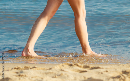Summer vacation. Female feet on the beach.