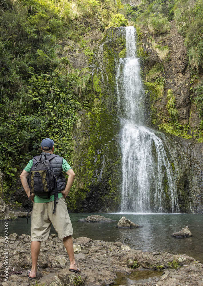 Man hiking to a beautiful tropical waterfall