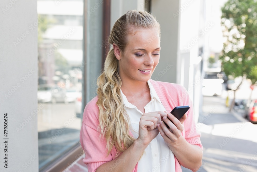 Pretty blonde sending a text message