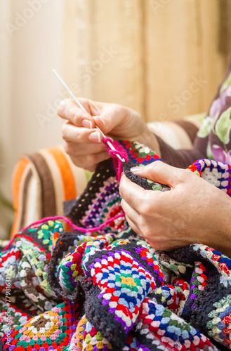 фотографія Hands of woman knitting a vintage wool quilt