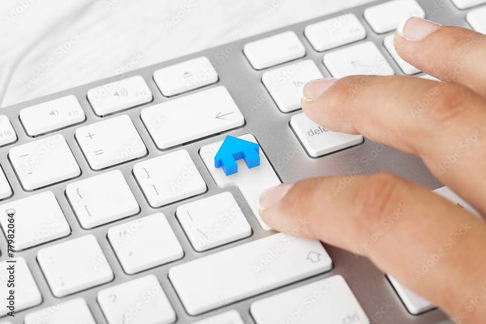 Woman hand touching new Home Key On Computer Keyboard Woman hand touching new Home Key On Computer Keyboard