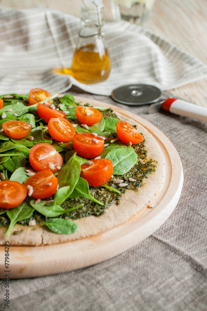 Pizza with pesto, spinach and cherry tomatoes
