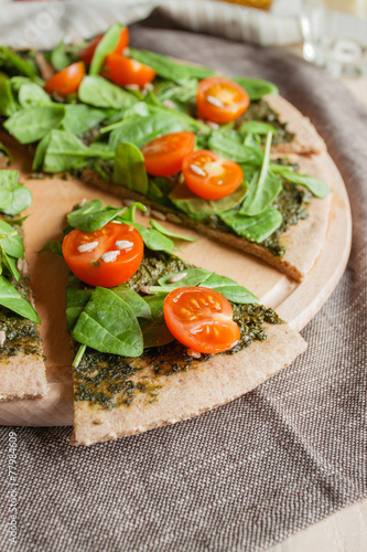 Pizza with pesto, spinach and cherry tomatoes