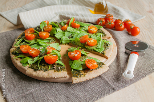 Pizza with pesto, spinach and cherry tomatoes