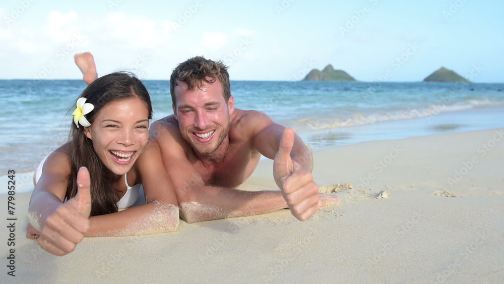 Beach vacation couple happy giving thumbs up Beach vacation couple happy giving thumbs up