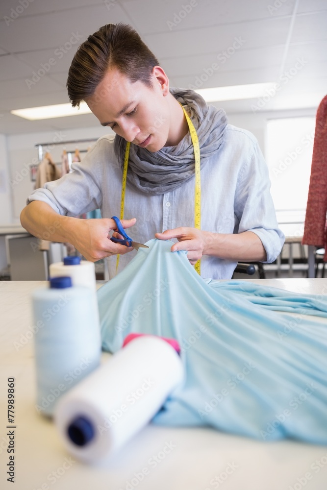 Student cutting fabric with pair of scissors Student cutting fabric with pair of scissors