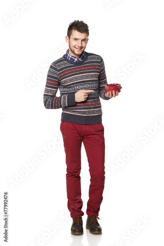 Young man with a heart-shaped gift isolated on white background.