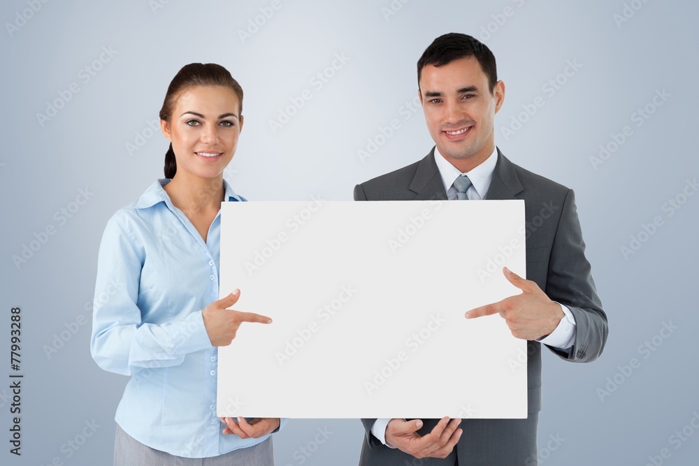 Composite image of business partners presenting sign together Composite image of business partners presenting sign together