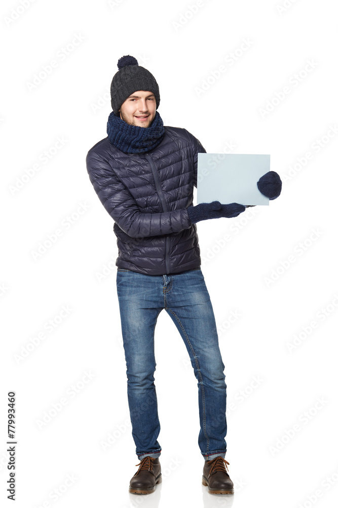 Full length portrait of a young man in winter clothing with empt