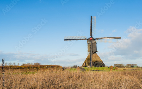 Obraz na plátně Dutch polder mill against a blue sky