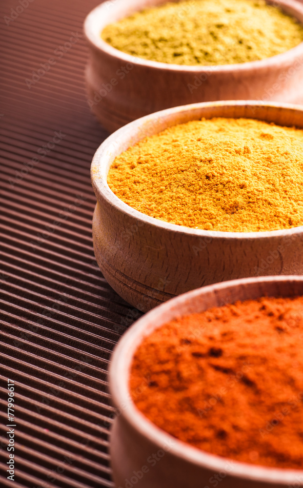 spices hops-suneli,turmeric,paprika in a wooden bowl close-up spices hops-suneli,turmeric,paprika in a wooden bowl close-up