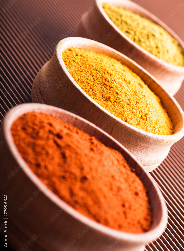 hops-suneli,turmeric,paprika in a wooden bowl close-up hops-suneli,turmeric,paprika in a wooden bowl close-up