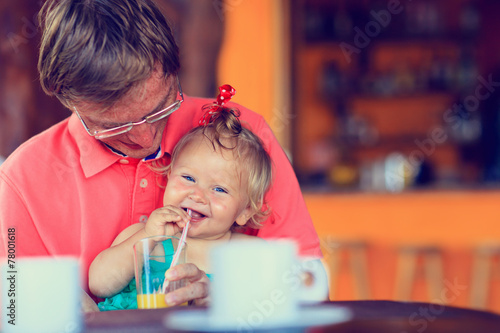 father and daughter having drink in cafe