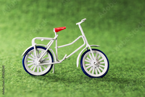 small toy bike on green background