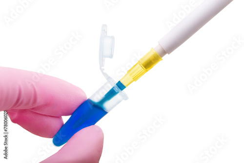 Hand in glove keeps plastic tube with dipped pipette