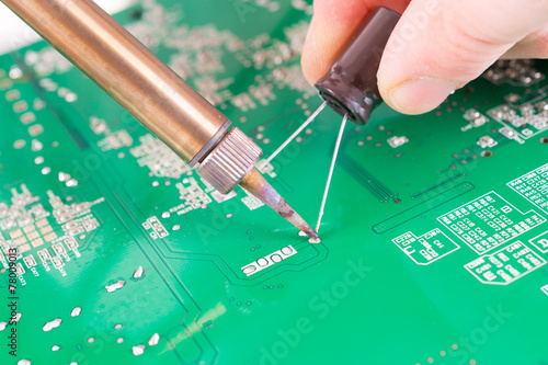 Serviceman soldering on PCB