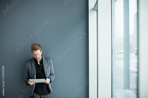 Man with tablet by the wall