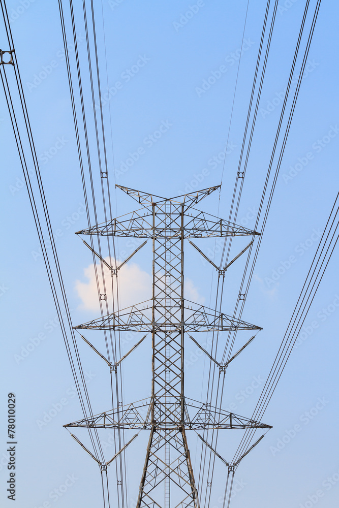 High tension electrical tower against blue sky