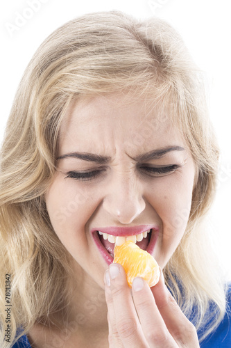 Model Released.  Young Woman Eating an Orange Segment