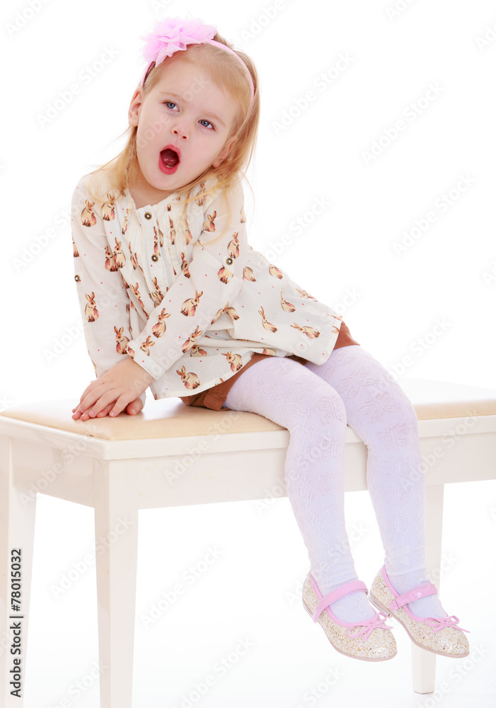 little girl yawns while sitting on the couch. little girl yawns while sitting on the couch.