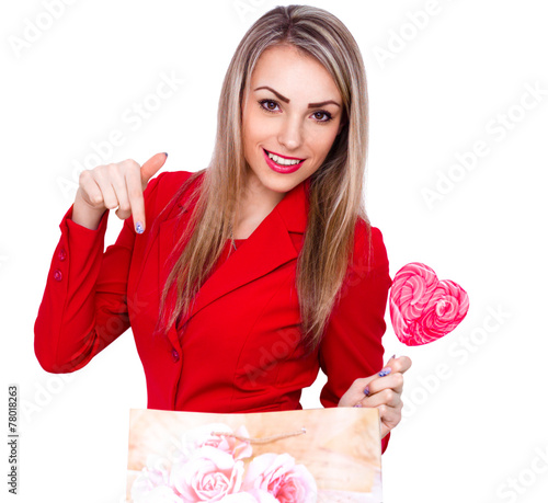 Smiling young woman with heart shaped lollipop on white