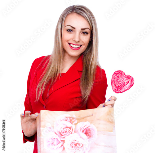Smiling young woman with heart shaped lollipop on white