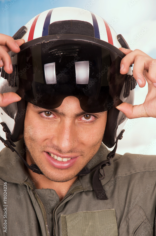 young handsome pilot wearing helmet over sky background young handsome pilot wearing helmet over sky background