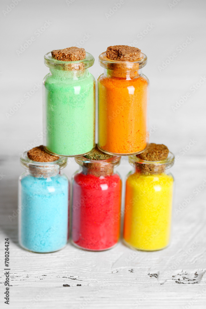 Bottles with colorful dry pigments on wooden background Bottles with colorful dry pigments on wooden background