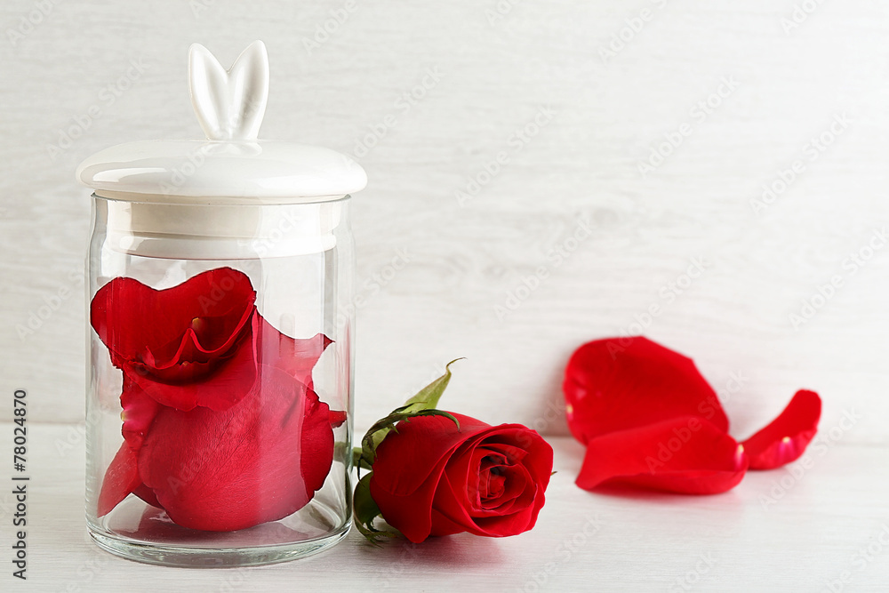 Rose flower in glass jar on light background - obrazy, fototapety, plakaty 