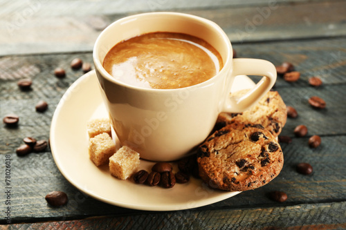 Cup of coffee and tasty cookies on wooden background