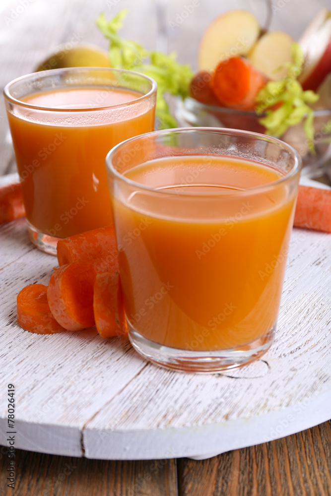 Glasses of juice with apple and carrot on wooden table close up Glasses of juice with apple and carrot on wooden table close up