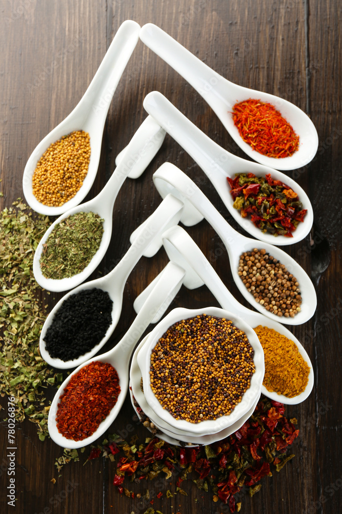 Different kinds of spices in ceramics spoons, close-up,