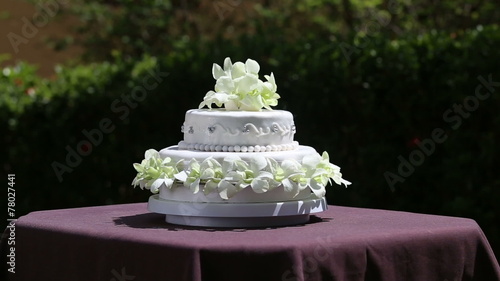 zoom on fresh white orchid and beads decorated wedding cake with